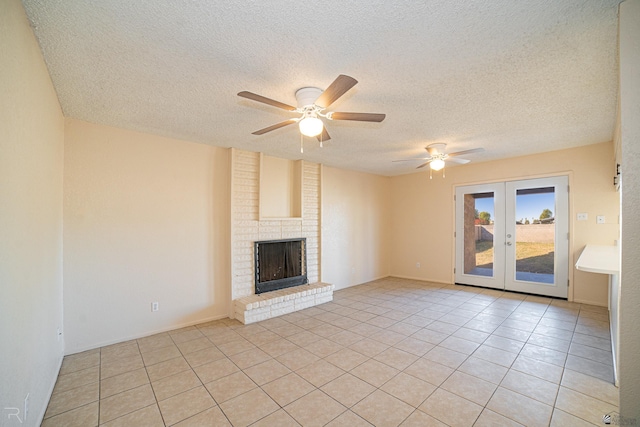 unfurnished living room with ceiling fan, french doors, a textured ceiling, a fireplace, and light tile patterned flooring