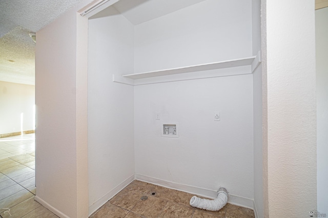 laundry room with electric dryer hookup, light tile patterned floors, and a textured ceiling