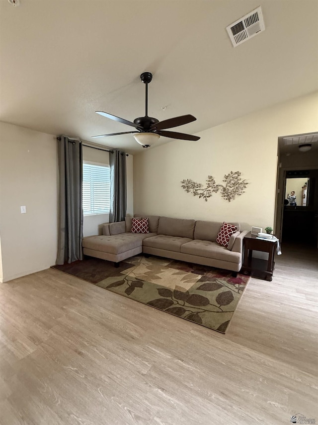 living room featuring a ceiling fan, wood finished floors, and visible vents