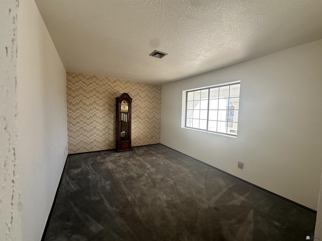 11651 E Via Salida, Yuma, AZ 85367 - unfurnished room with an accent wall, dark carpet, a textured ceiling, and visible vents