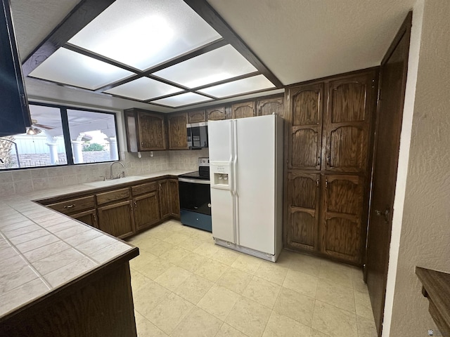 11651 E Via Salida, Yuma, AZ 85367 - kitchen featuring a sink, tile counters, stainless steel microwave, electric stove, and white fridge with ice dispenser