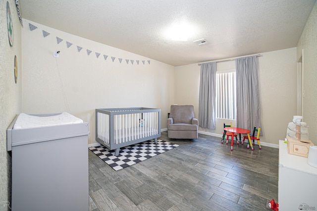 6340 E 45th Pl, Yuma, AZ 85365 - bedroom featuring wood finished floors, a crib, a textured ceiling, and baseboards