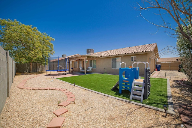 6340 E 45th Pl, Yuma, AZ 85365 - rear view of house with a trampoline, stucco siding, a patio, and a tile roof