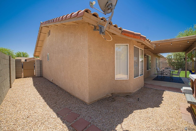 6340 E 45th Pl, Yuma, AZ 85365 - view of property exterior with stucco siding, a fenced backyard, a gate, a patio, and a tile roof