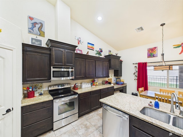 5936 E 39th St, Yuma, AZ 85365 - kitchen with stainless steel appliances, a sink, lofted ceiling, dark brown cabinetry, and decorative light fixtures