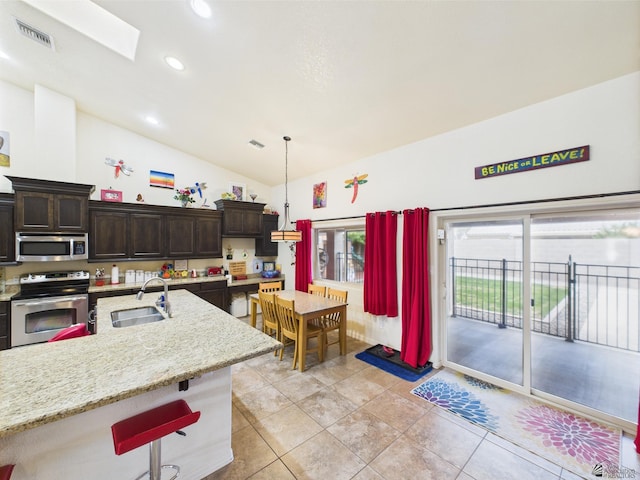 5936 E 39th St, Yuma, AZ 85365 - kitchen with stainless steel appliances, a sink, dark brown cabinets, vaulted ceiling, and recessed lighting