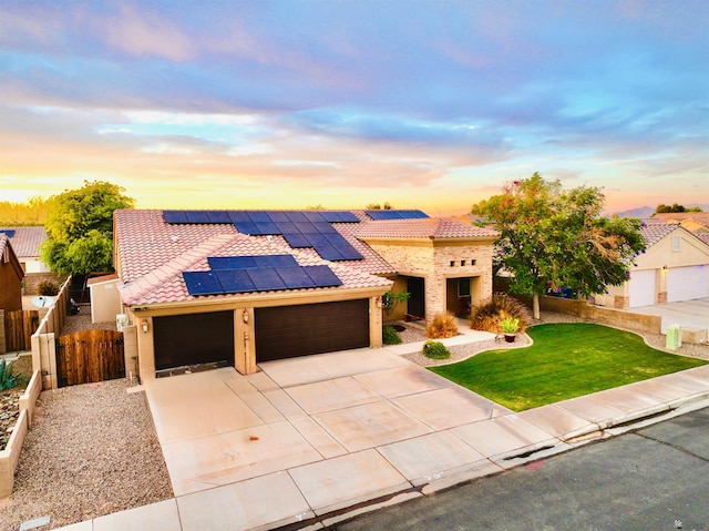5936 E 39th St, Yuma, AZ 85365 - mediterranean / spanish home with a tile roof, a garage, stucco siding, roof mounted solar panels, and concrete driveway