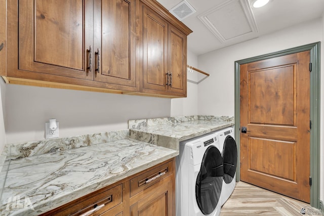 washroom with cabinet space, visible vents, and washing machine and clothes dryer