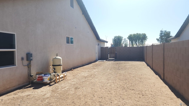 view of property exterior with fence, a gate, and stucco siding