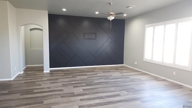unfurnished room featuring ceiling fan, visible vents, wood finished floors, baseboards, and recessed lighting