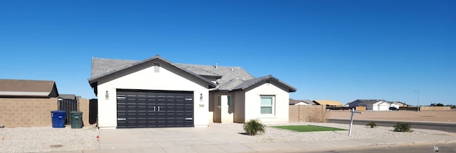 ranch-style house featuring fence, an attached garage, stucco siding, a gate, and driveway