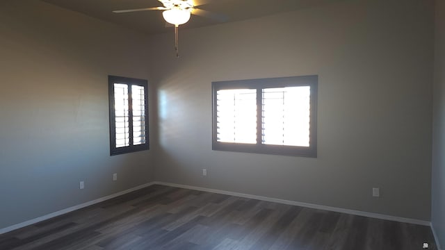 empty room featuring baseboards, ceiling fan, and dark wood finished floors