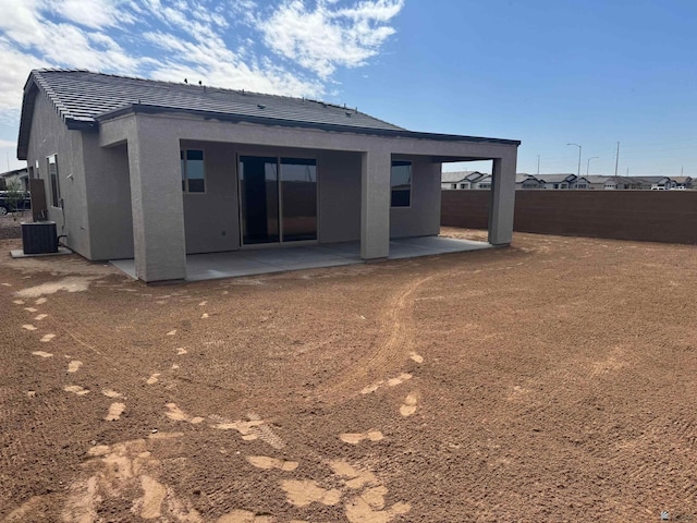 rear view of house with a tiled roof, fence, a patio area, and stucco siding