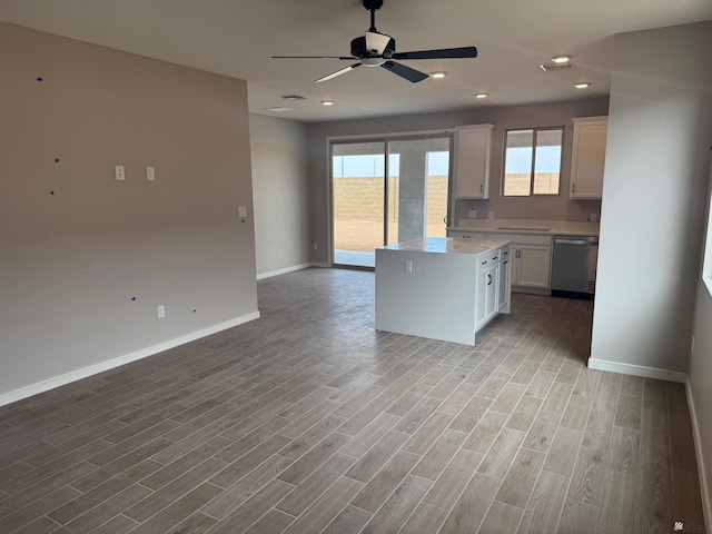 kitchen with baseboards, open floor plan, ceiling fan, light countertops, and dishwasher