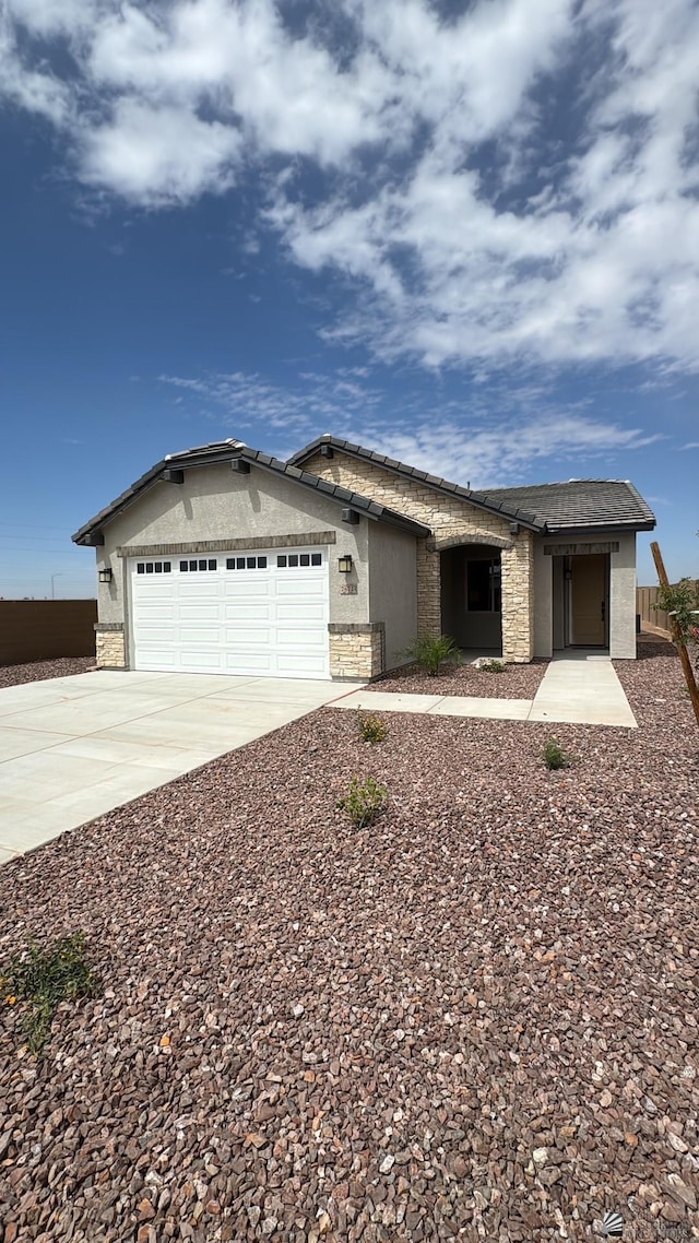 ranch-style home featuring a garage, stucco siding, driveway, and stone siding