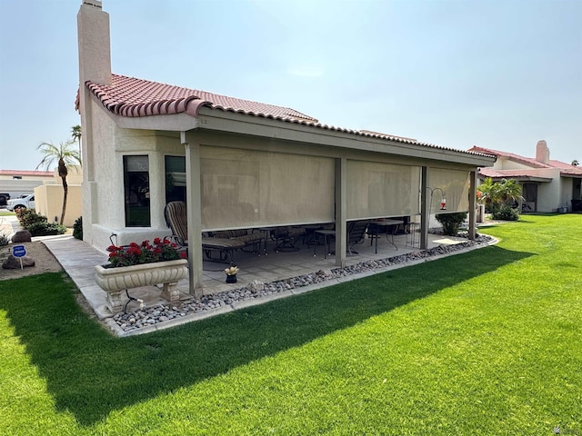 10193 S Del Rey Dr, Yuma, AZ 85367 - rear view of house with a patio, stucco siding, a chimney, a lawn, and a tile roof