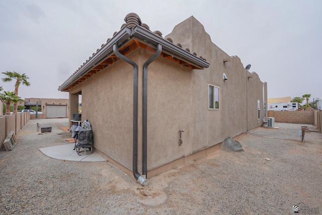 12806 E 49th Dr, Yuma, AZ 85367 - view of side of home with fence, stucco siding, and central AC