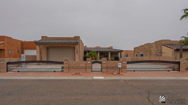 12806 E 49th Dr, Yuma, AZ 85367 - southwest-style home featuring a tiled roof, a fenced front yard, a gate, a garage, and stucco siding