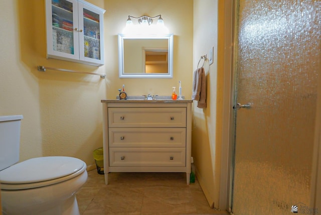 12806 E 49th Dr, Yuma, AZ 85367 - bathroom featuring a shower with shower door, vanity, toilet, tile patterned floors, and baseboards
