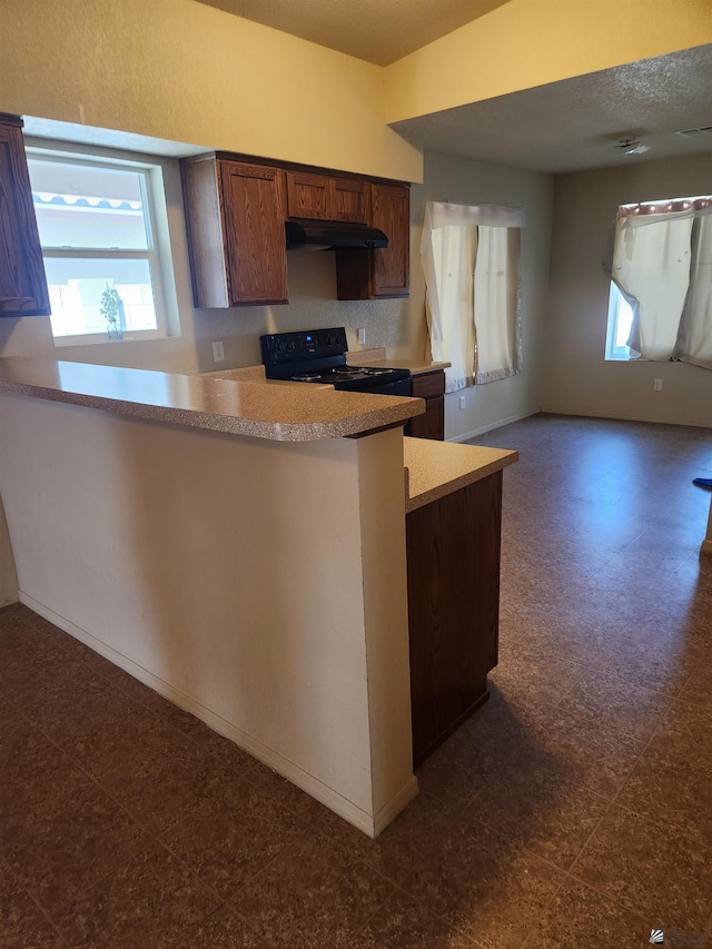 3708 S Desert Oasis Dr, Yuma, AZ 85365 - kitchen with black range with electric stovetop, under cabinet range hood, light countertops, a peninsula, and dark floors