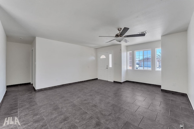 unfurnished living room featuring visible vents, baseboards, and a ceiling fan