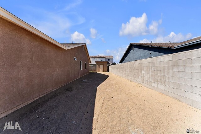 view of yard with an outbuilding, a fenced backyard, and a storage shed