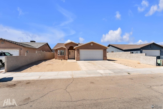 single story home featuring concrete driveway, an attached garage, fence, and stucco siding