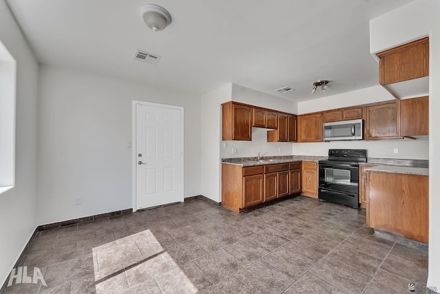 kitchen featuring stainless steel microwave, electric range, baseboards, and visible vents