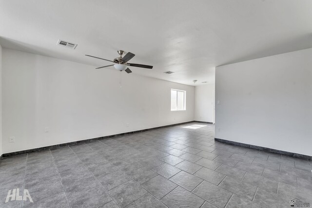 spare room featuring visible vents, ceiling fan, and baseboards