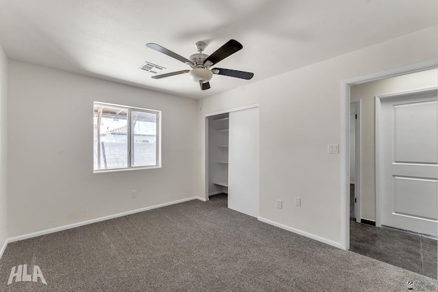 unfurnished bedroom featuring a closet, baseboards, visible vents, and dark colored carpet