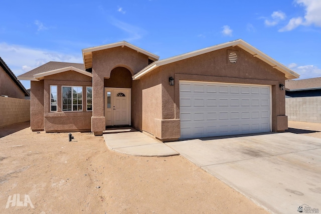 ranch-style home with stucco siding, a garage, concrete driveway, and fence