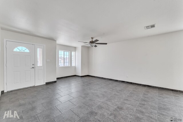 foyer entrance with baseboards, visible vents, and ceiling fan