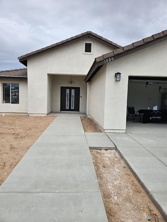 10778 E 45th Pl, Yuma, AZ 85367 - view of front facade featuring an attached garage, stucco siding, and french doors