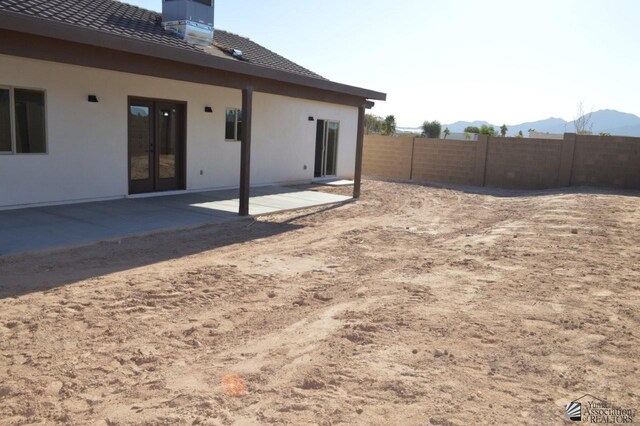 13112 E 54th St, Yuma, AZ 85367 - rear view of property featuring a patio, a mountain view, stucco siding, and a chimney