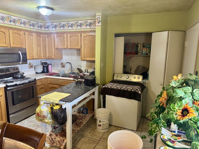 219 E Rio Sonora St, San Luis, AZ 85336 - kitchen featuring appliances with stainless steel finishes, washer / dryer, light brown cabinets, a textured ceiling, and light tile patterned flooring