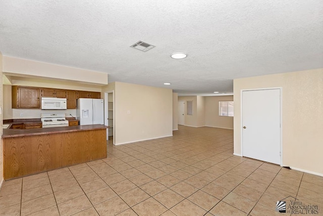11279 E 26th Ln, Yuma, AZ 85367 - kitchen featuring white appliances, a peninsula, open floor plan, dark countertops, and a textured ceiling