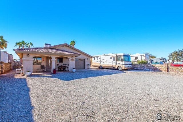 13405 E 54th St, Yuma, AZ 85367 - view of front of property featuring aphalt driveway, fence, stucco siding, a tiled roof, and an attached garage