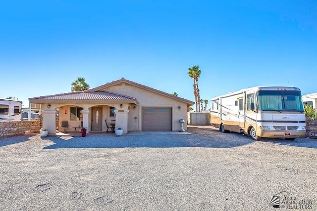 13405 E 54th St, Yuma, AZ 85367 - view of front facade with a tile roof, a garage, fence, gravel driveway, and stucco siding