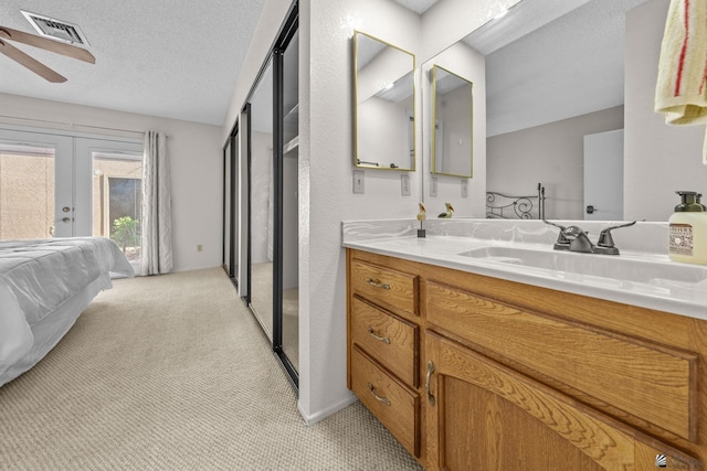 11230 E 37th Pl Unit 131, Yuma, AZ 85367 - bathroom with a ceiling fan, vanity, french doors, and a textured ceiling