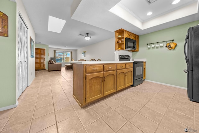 11230 E 37th Pl Unit 131, Yuma, AZ 85367 - kitchen featuring black appliances, a peninsula, a skylight, open shelves, and light tile patterned flooring