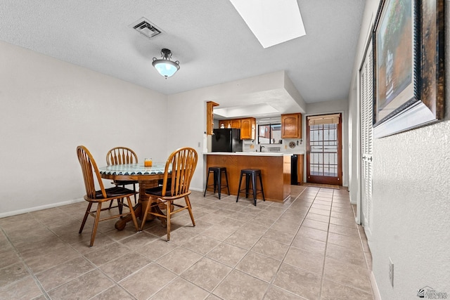 11230 E 37th Pl Unit 131, Yuma, AZ 85367 - dining space with a skylight, light tile patterned flooring, and a textured ceiling