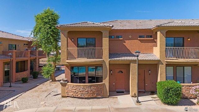 3591 W 22 Street 3591W 22Nd Street, #E, Yuma, AZ 85364 - townhome / multi-family property with a tiled roof, a balcony, and stucco siding