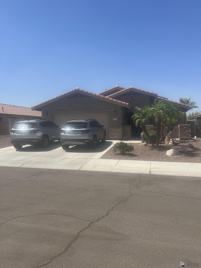 13734 E 45th Dr, Yuma, AZ 85367 - view of front facade with a garage, driveway, a tiled roof, and stucco siding
