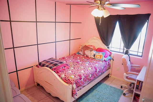tiled bedroom featuring baseboards and a ceiling fan