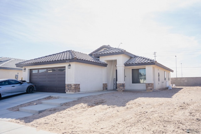 view of front facade featuring an attached garage, a tile roof, and stone siding
