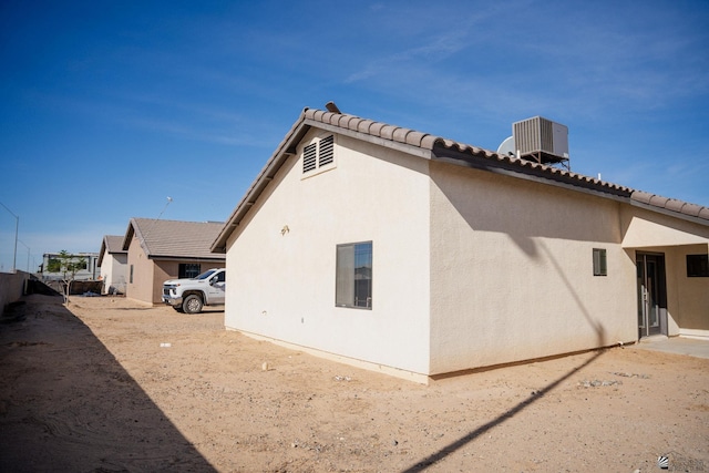 view of home's exterior featuring stucco siding, central AC, and a tile roof