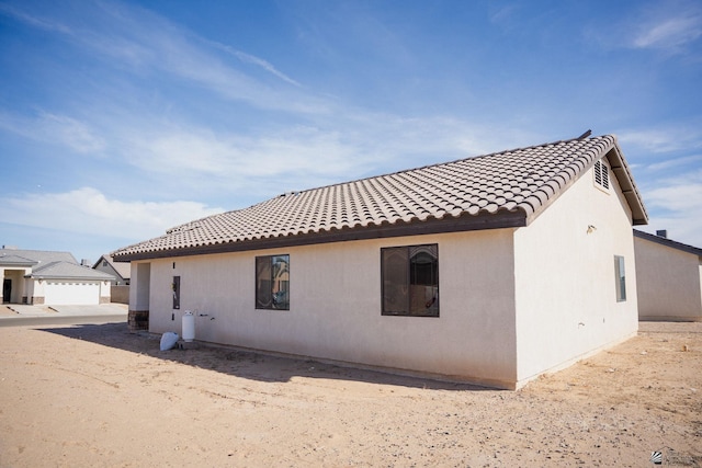 back of house with a tile roof