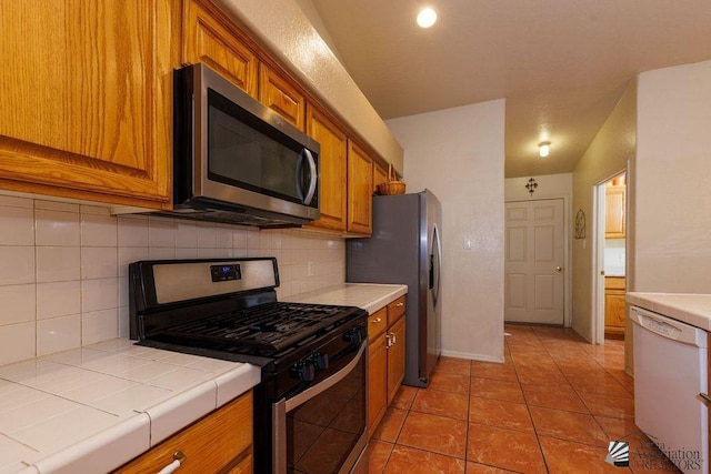 3769 W 25th Ln, Yuma, AZ 85364 - kitchen featuring appliances with stainless steel finishes, tile countertops, brown cabinets, and decorative backsplash
