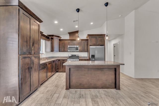 kitchen featuring lofted ceiling, a sink, dark brown cabinets, appliances with stainless steel finishes, and light wood-type flooring