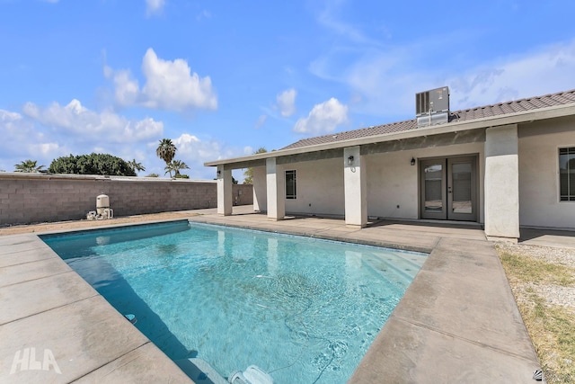 view of swimming pool with a fenced in pool, a fenced backyard, french doors, central air condition unit, and a patio area